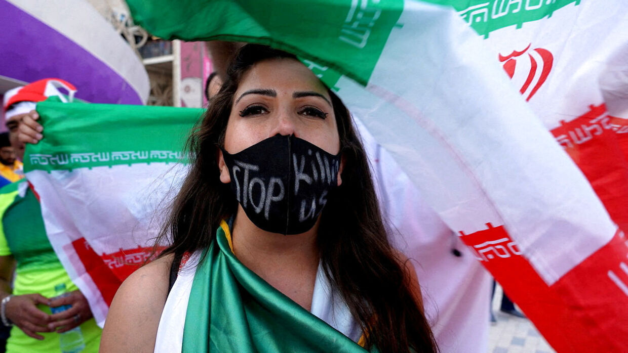 En kvinde bærer en maske med teskten "Stop med at dræbe os," efter Irans kamp mod Wales ved VM i Qatar