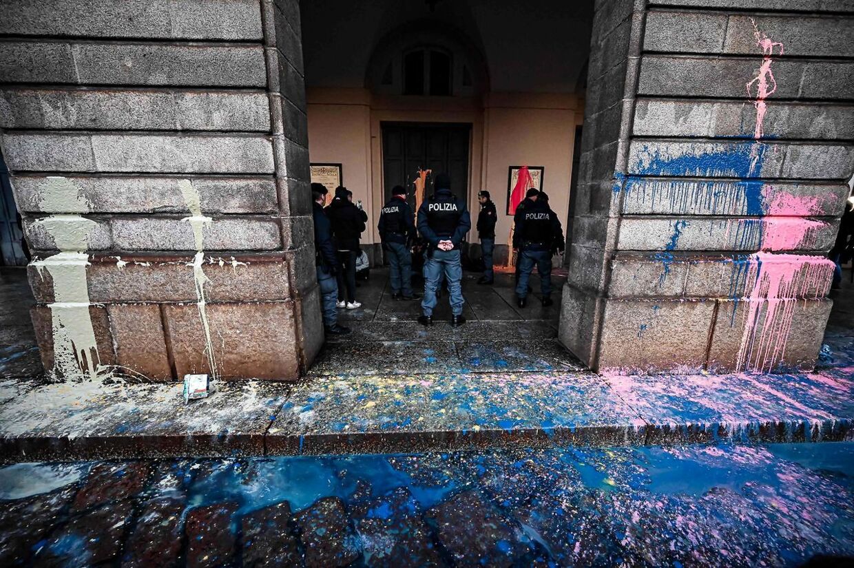 Police officers detain environmental activists from the "Last Generation" (Ultima Generazione) group after they smeared with paint the facade of the La Scala theatre during a group's action in Milan on December 7, 2022, aimed at raising awareness about climate change on the day of La Scala's new season's opening. (Photo by Piero CRUCIATTI / AFP)