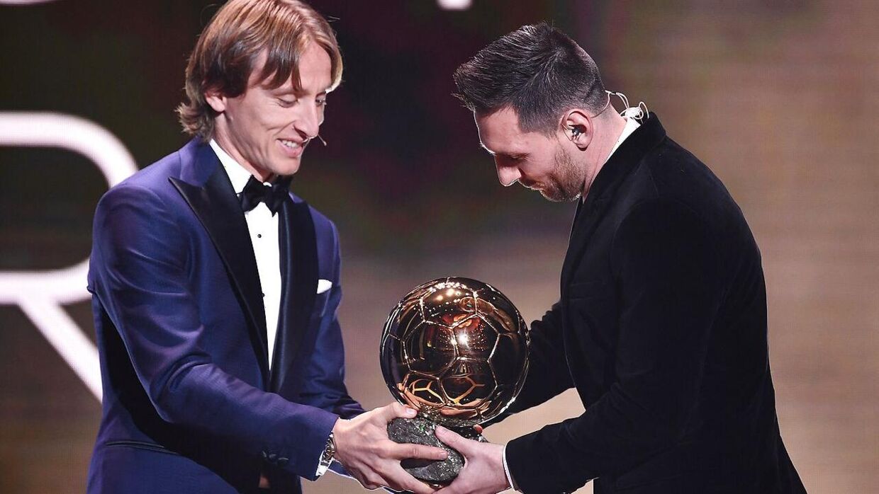 Luka Modric overrækker Ballon d'Or-trofæet til Lionel Messi i 2019.
