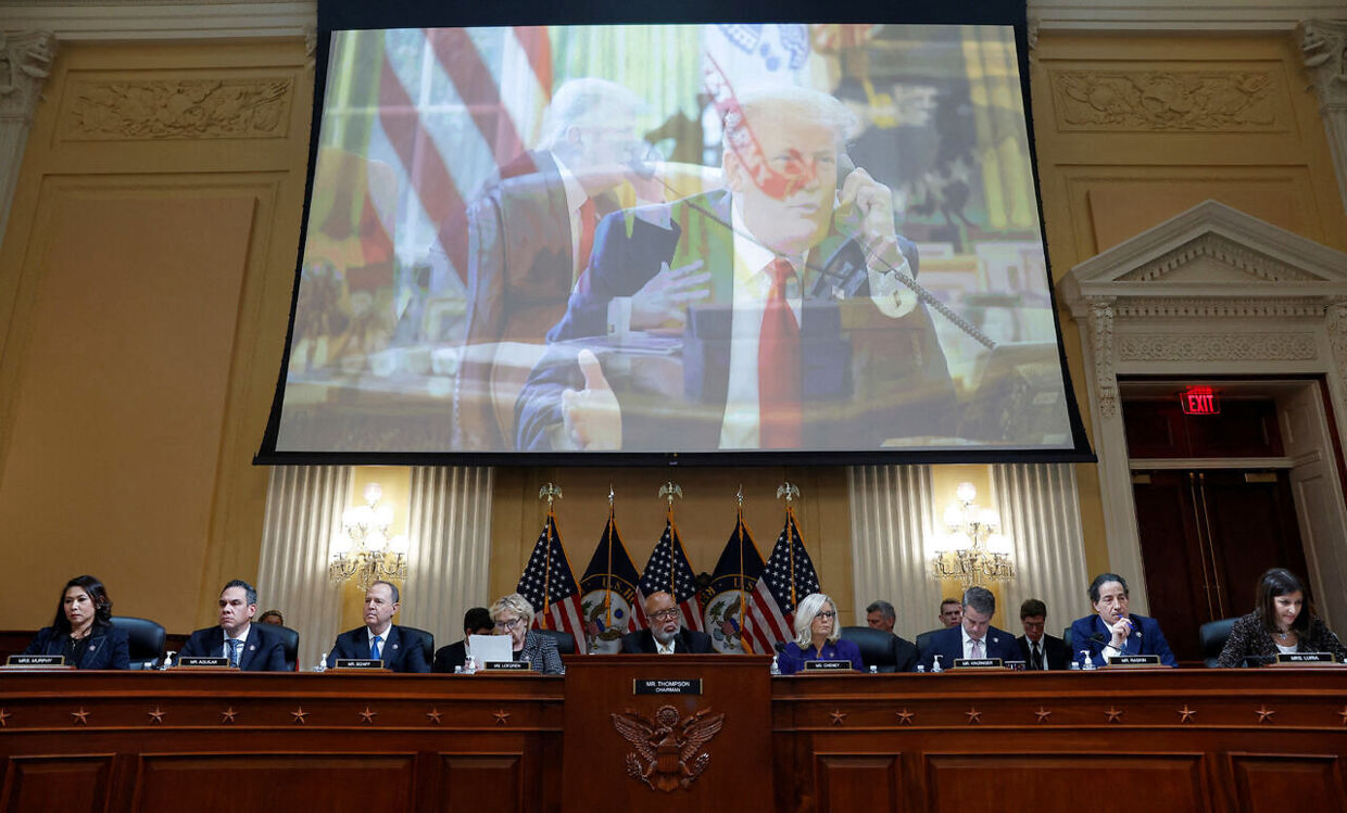 De ni udvalgsmedlemmer under en videoskærm med Donald Trump ved mandagens udmelding. 