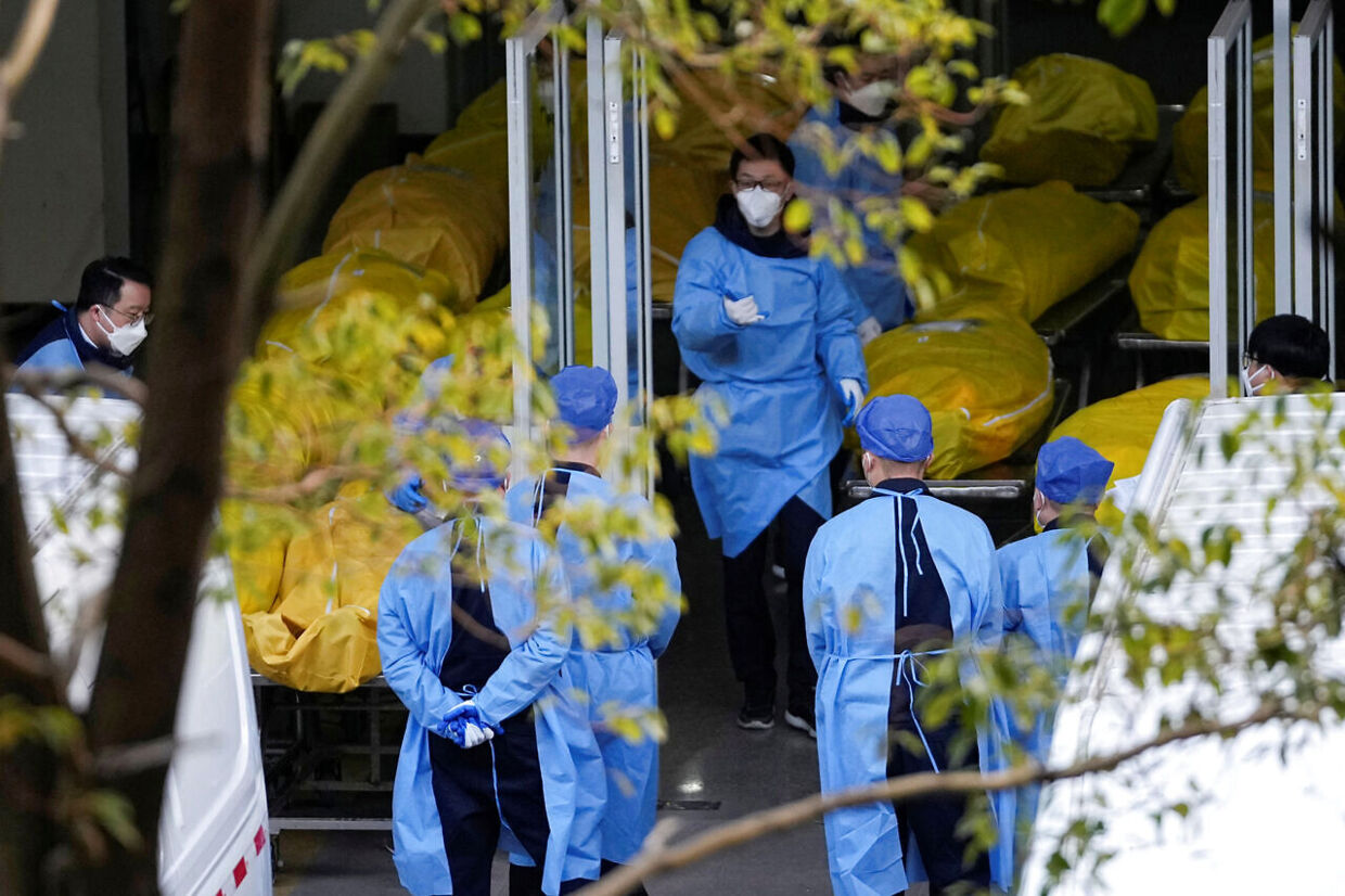 Sundhedsarbejdere i Shanghai står mellem dusinvis af ligposer. Kina er forsat tilbageholdende med at dele information om den igangværende covid-epidemi.