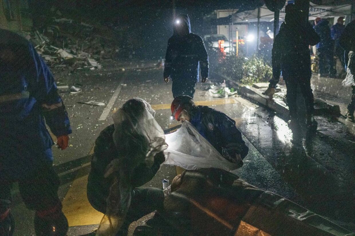 Rescue workers help a wounded person next to the rubble in Hatay on February 6, 2023, after a 7.8-magnitude earthquake struck the country's south-east. - A major 7.8-magnitude earthquake struck Turkey and Syria, killing more than 3, 000 people and flattening thousands of buildings as rescuers dug with bare hands for survivors. (Photo by BULENT KILIC / AFP)