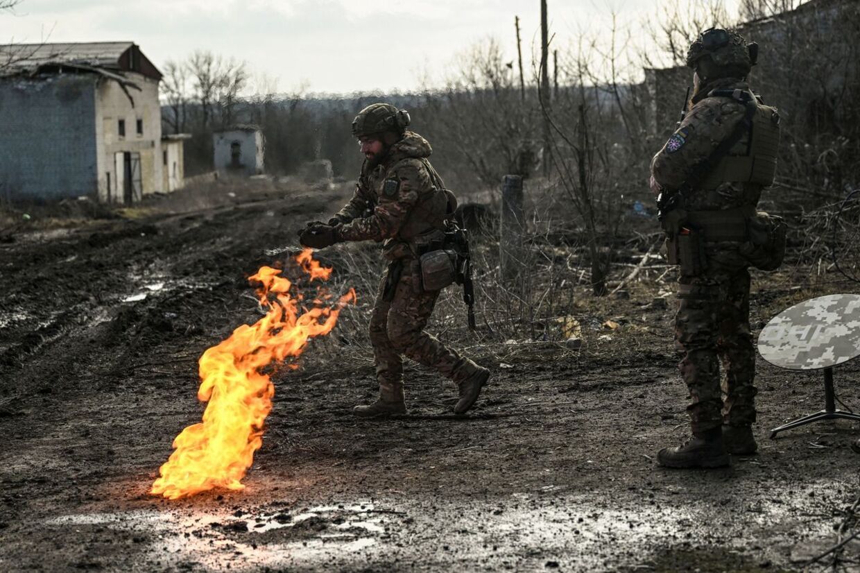 En ukrainsk soldat tænder et bål ved hjælp af krudt for at holde varmen nær Bakhmut.