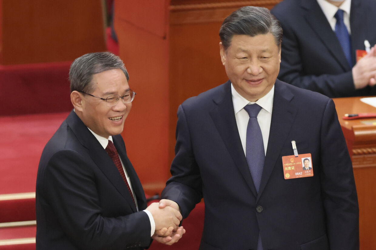 Li Qiang (til venstre) bliver lykønsket med premierministerposten af præsident Xi Jinping. Ichiro Ohara/Ritzau Scanpix