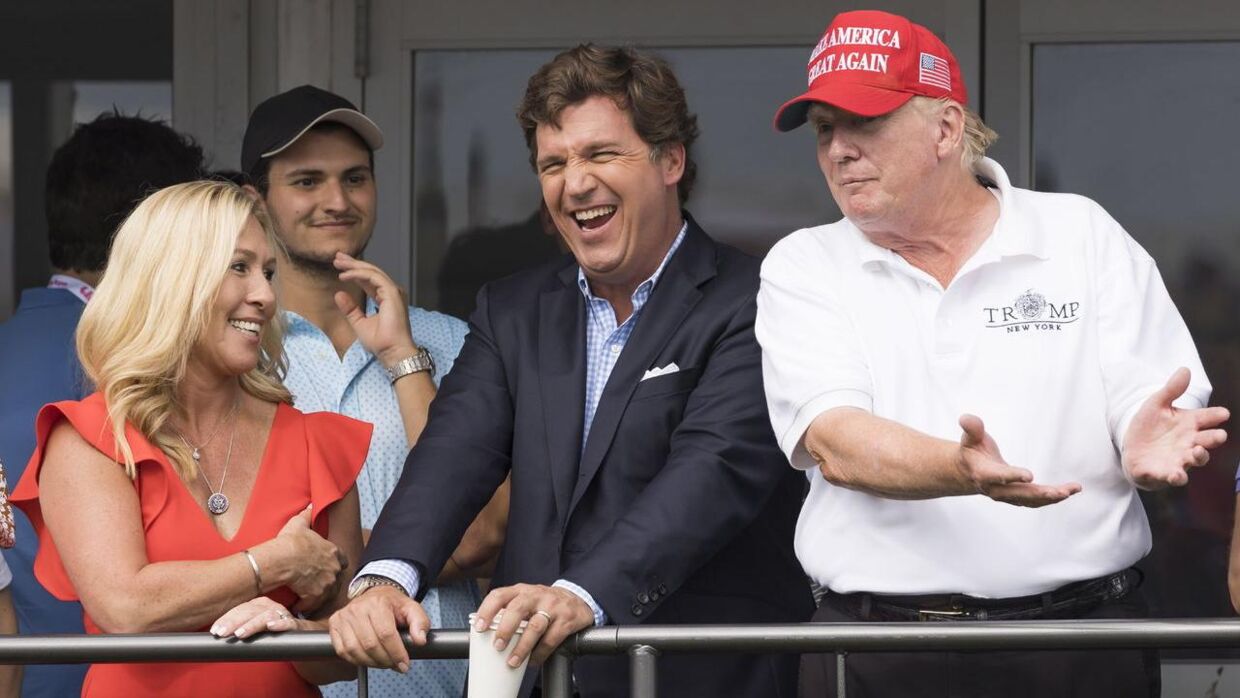 Fox News-værten Tucker Carlson (i midten) med Donald Trump (th.) og kongresmedlemmet Marjorie Taylor Greene ved en golfturnering på et Trump-resort.