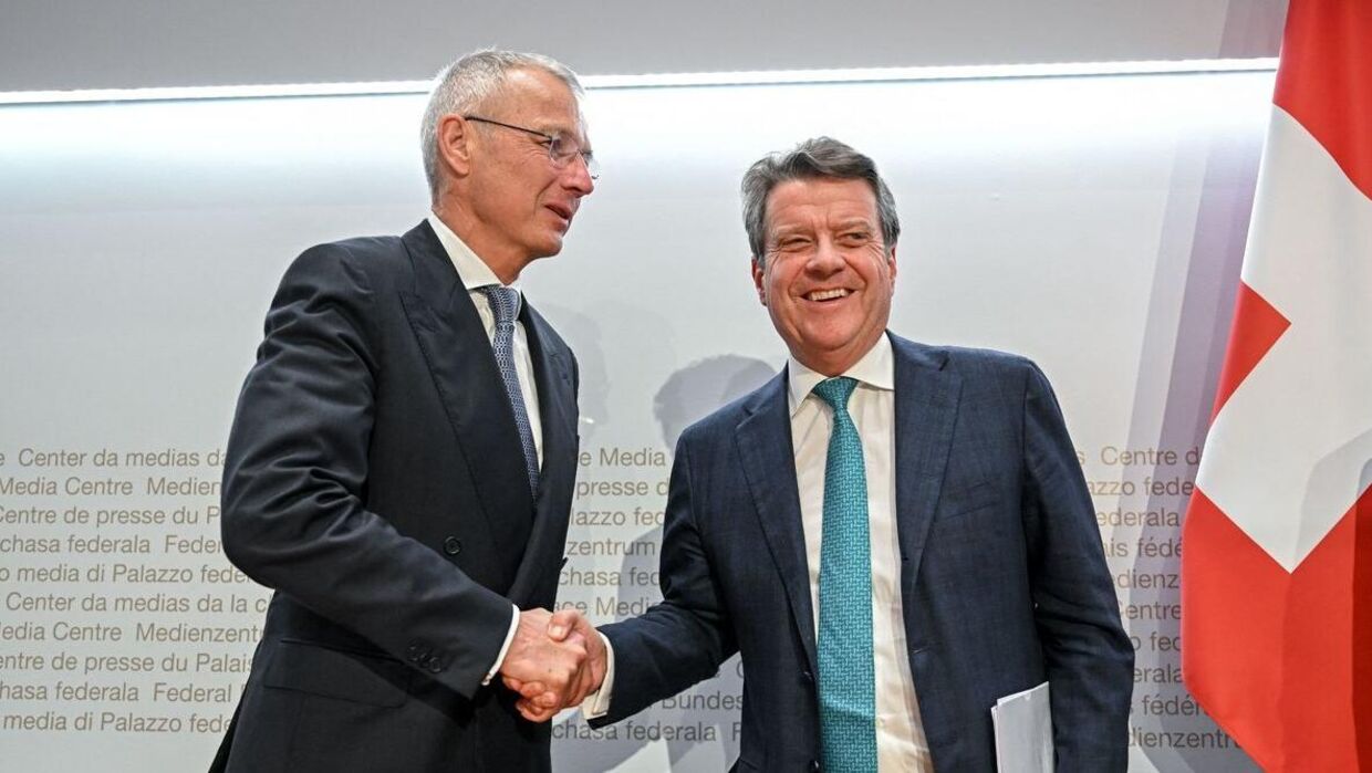UBS formand Colm Kelleher giver hånd til Credit Suisses formand, Axel Lehmann (tv) efter en pressekonference søndag.