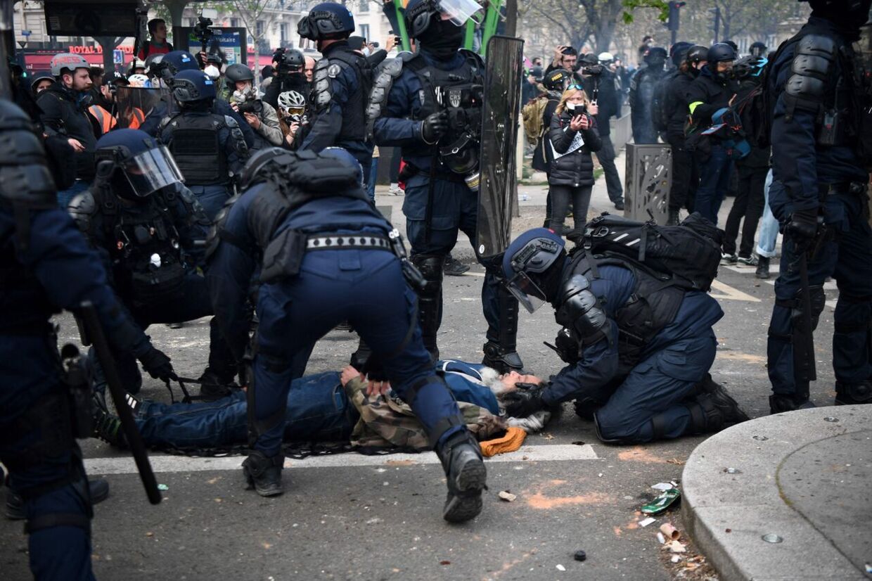 Fransk politi hjælper en såret demonstrant under de voldesomme optøjer tirsdag aften