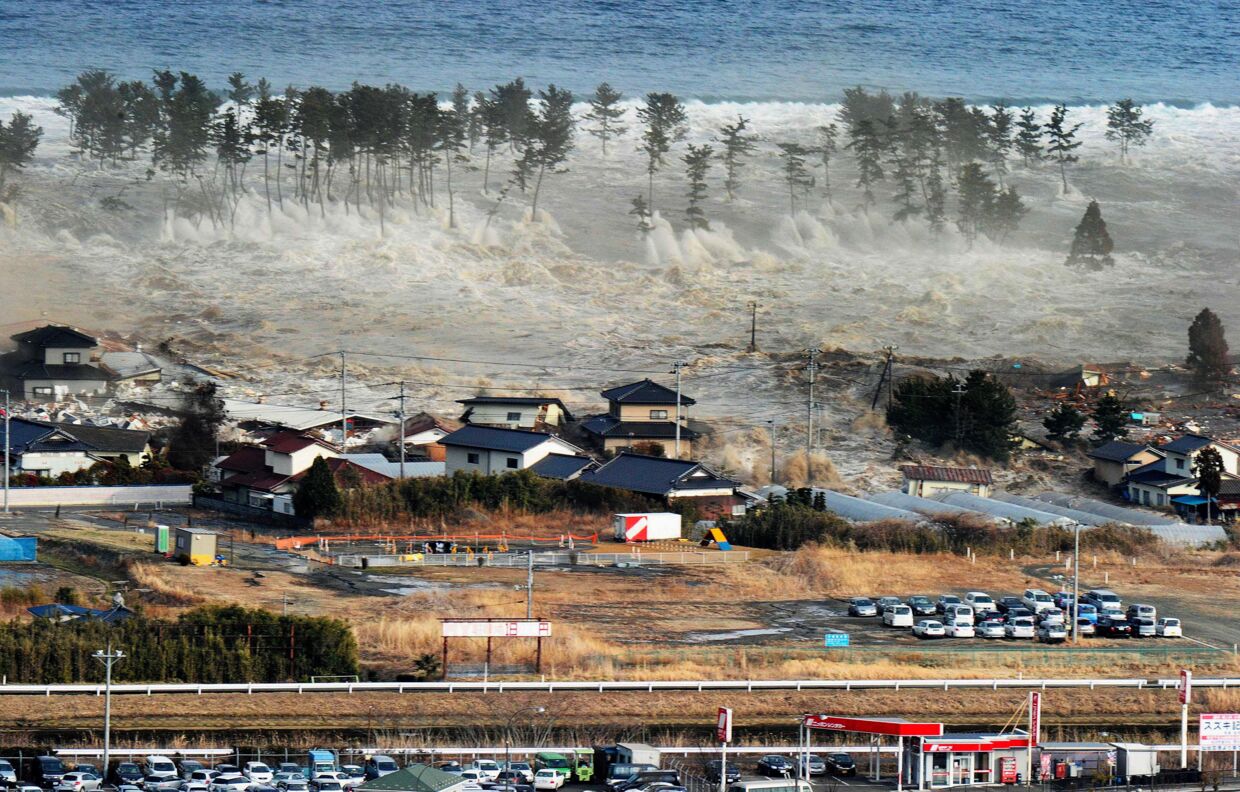 Tsunamien rammer Japans kyst her og har allerede fat i de første huse.