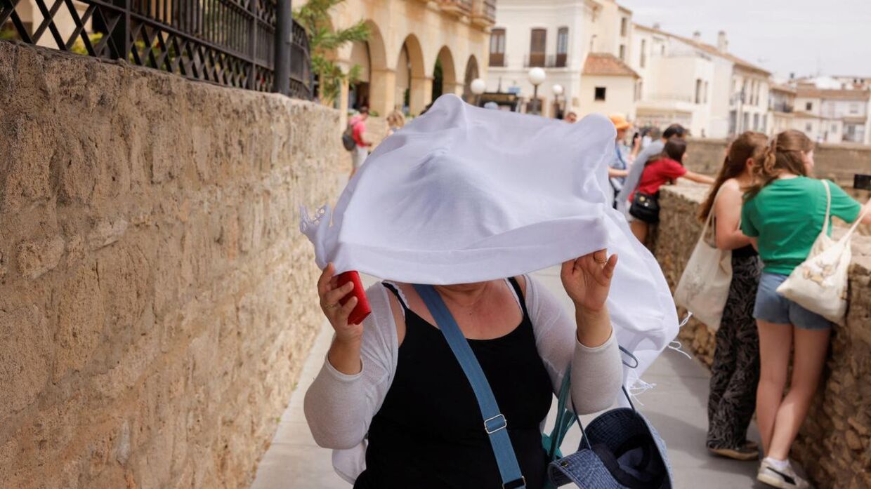 En kvinde forsøger at beskytte sig mod den brændende sol i Ronda, der ligger vest for Malaga.