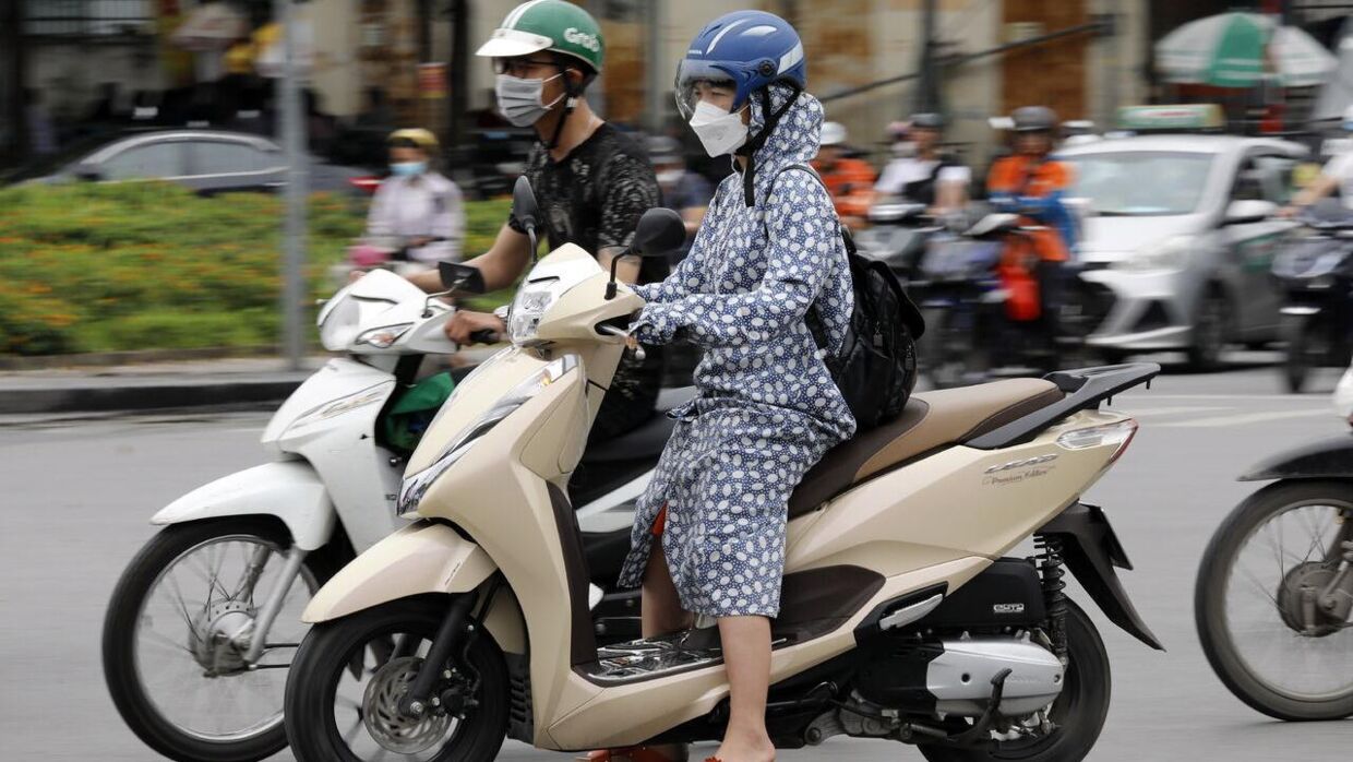En kvinde på en scooter bærer langt tøj for at beskytte sig mod den ekstreme varme i Hanoi 8. maj 2023.