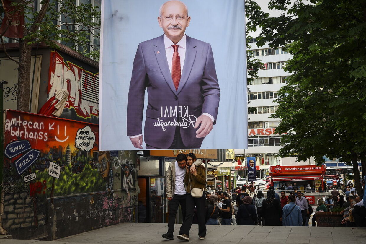 Et par går under en plakat af den tyrkiske præsidentkandidat Kemal Kilicdaroglu, leder af det oppositionelle Republikanske Folkeparti (CHP), dagen efter parlamentsvalget i Ankara, Tyrkiet, 15. maj 2023.
