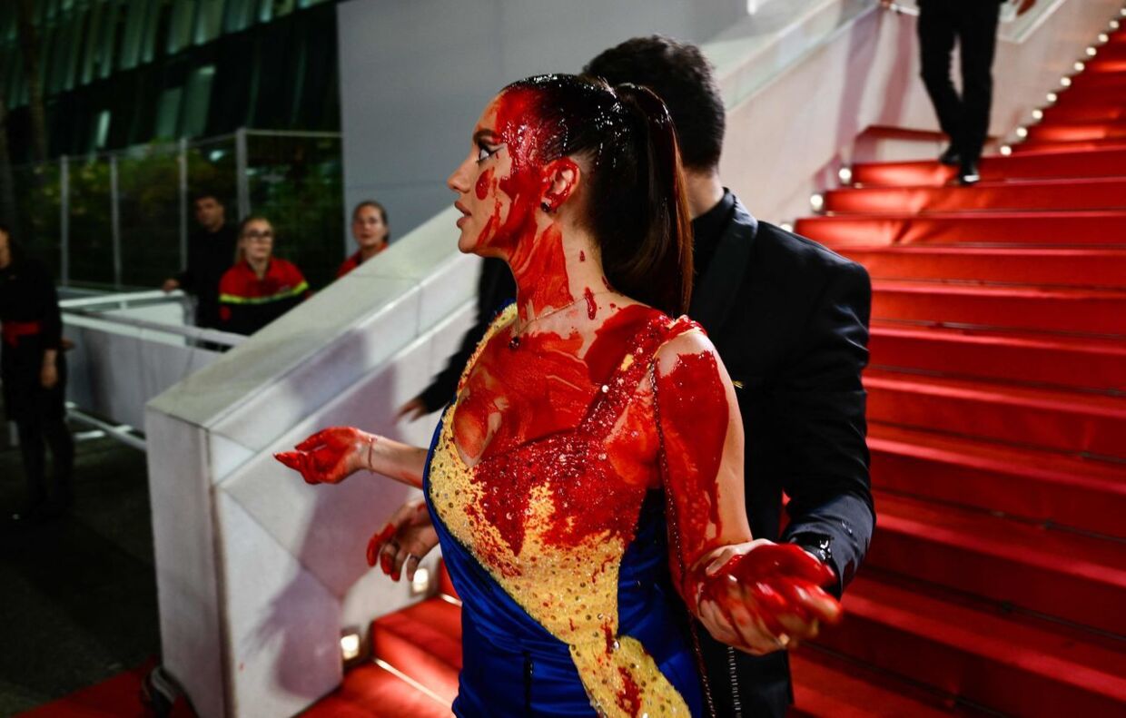 En demonstrant iført en kjole i Ukraines farver hældte blod ud over sig selv.