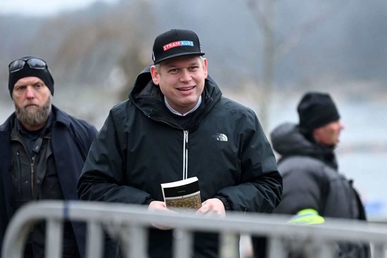 (FILES) In this file photo taken on January 21, 2023 the leader of the far-right Danish political party Stram Kurs, Swedish-Danish politician Rasmus Paludan is pictured while holding an edition of The Quran (Koran), the central religious text of Islam, while staging a protest outside the Turkish Embassy in Stockholm, Sweden. - A Swedish court on April 4, 2023 overturned a police decision to ban two Koran burning protests, saying security risk concerns were not enough to limit the right to demonstrate. The burning of Islam's holy book outside Turkey's embassy in Stockholm in January angered the Muslim world, sparking weeks of protests and calls for a boycott of Swedish goods, and stymieing Sweden's NATO membership bid. (Photo by Fredrik SANDBERG / TT News Agency / AFP) / Sweden OUT