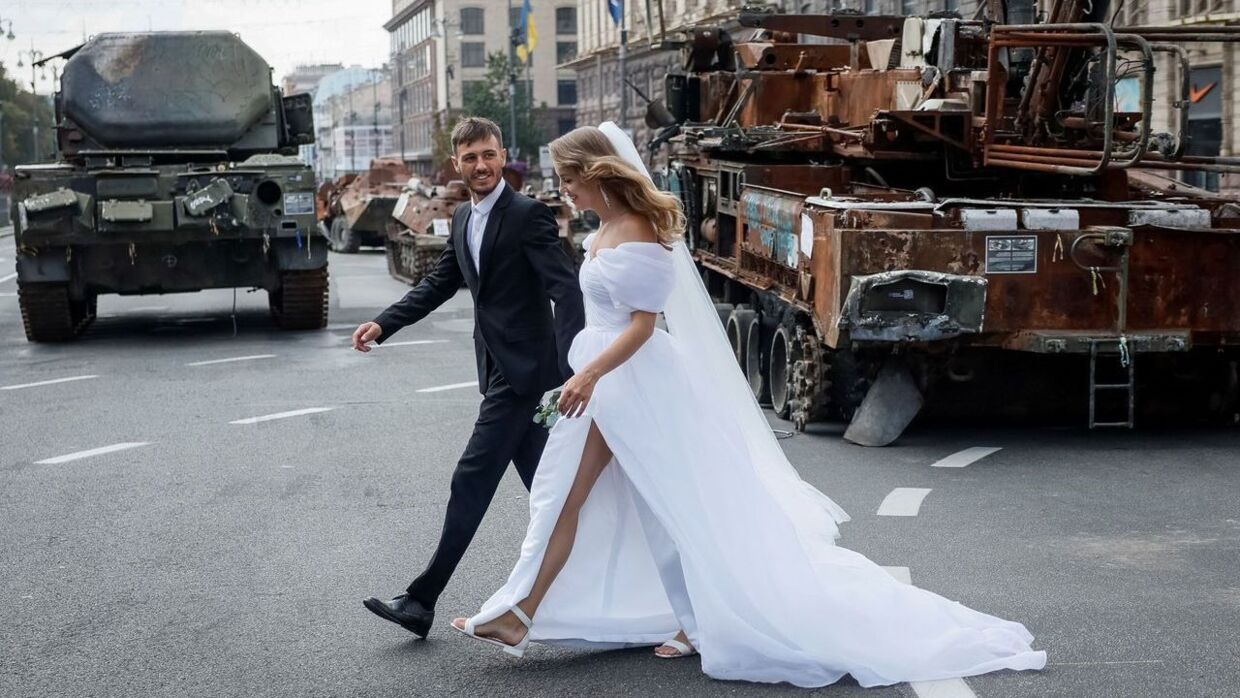 Et brudepar besøger udstillingen af de ødelagte russiske kampvogne i det centrale Kyiv.