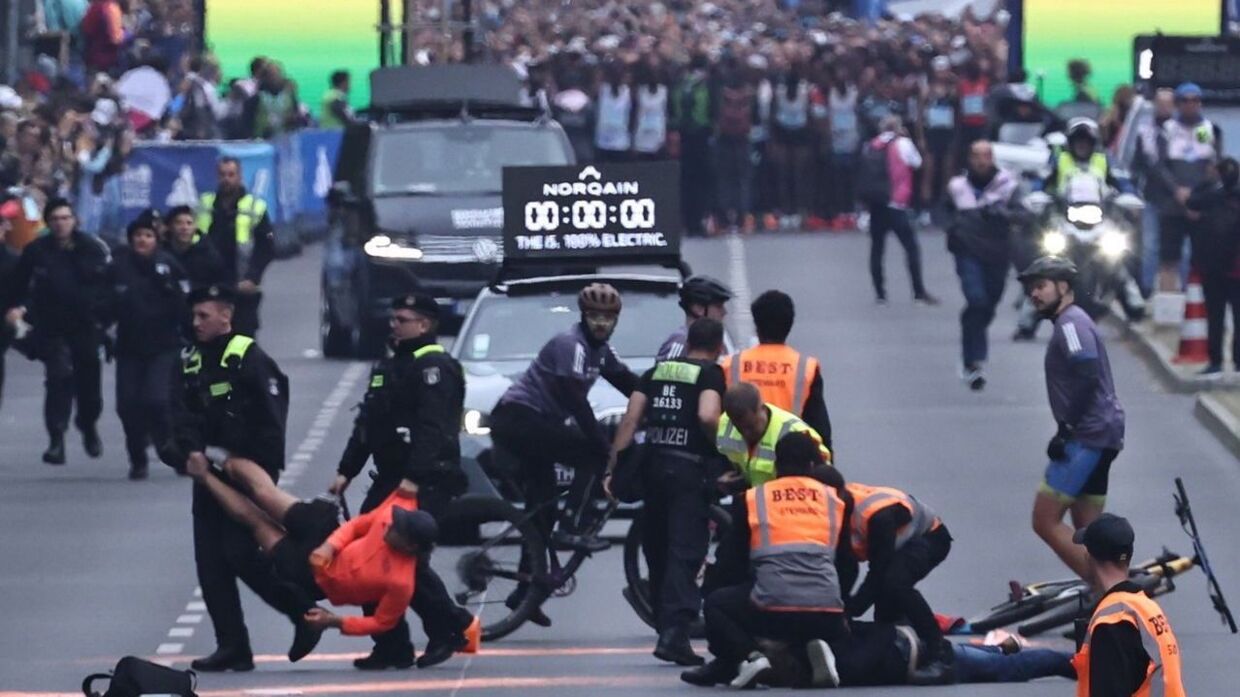 epa10879999 Police officers remove climate activists of the 'Last Generation' group after an attempt to block the street ahead of the Berlin Marathon 2023, in Berlin, Germany, 24 September 2023. EPA/CLEMENS BILAN