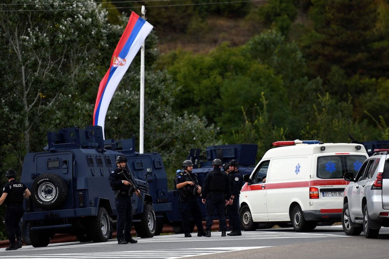 Politifolk holder vagt ved en vej, der fører til landsbyen Banjska. Den var søndag ramme om sammenstød mellem bevæbnede mænd og politi. Fire er dræbt, blandt dem en politimand.