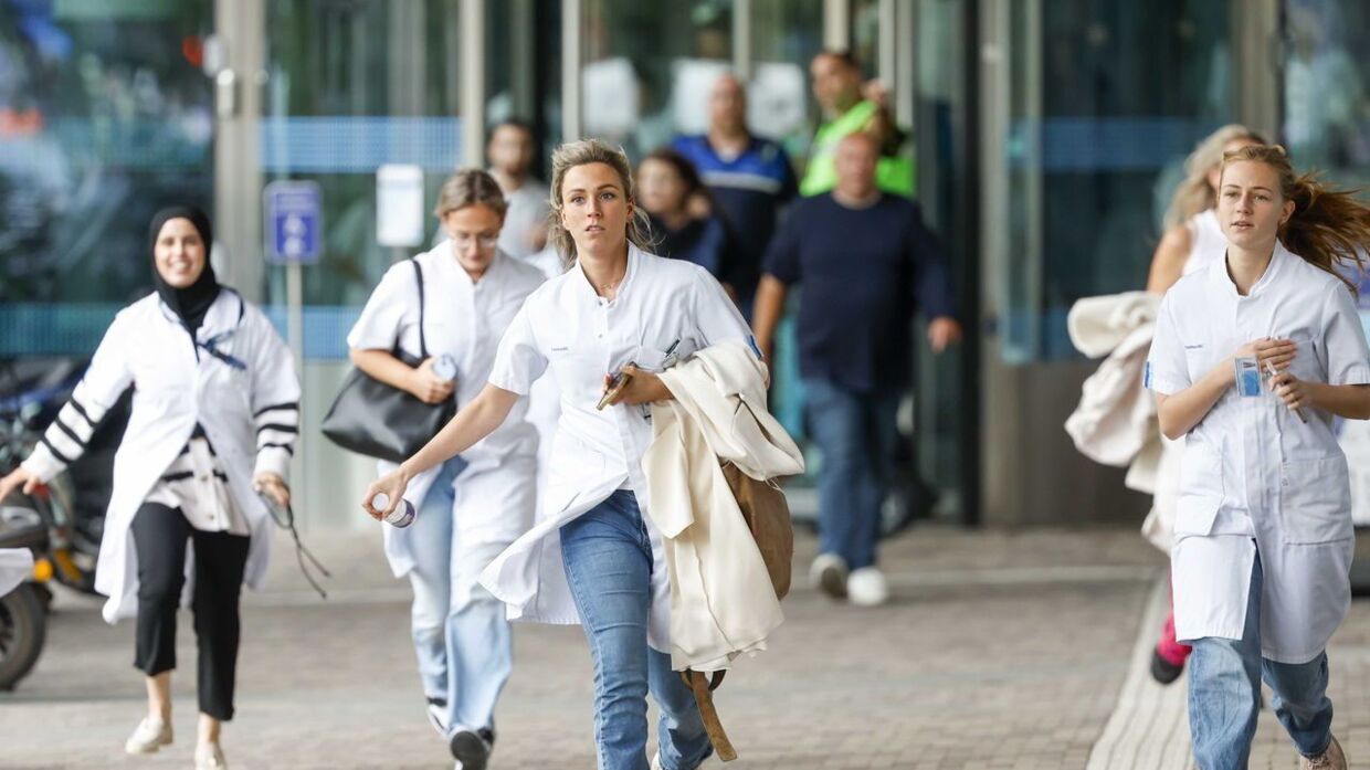 Personalet flygter fra hospitalet i Rotterdam efter skudepisoden torsdag eftermiddag. 