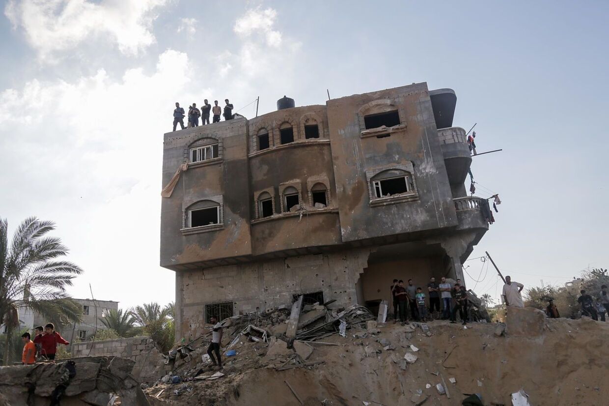 Palæstinensere leder efter døde og overlevende i ruinerne af et boligbyggeri efter et israelsk luftangreb mopd Khan Younis i den sydlige del af Gaza-striben. 16. oktober 2023.