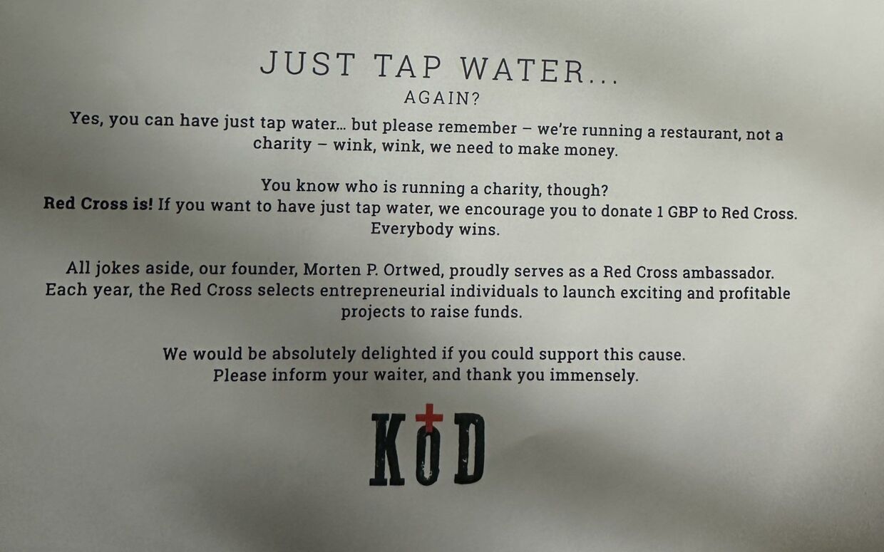 Her ses hele formuleringen om postevandet på Köds menukort. Hvor det altså fremgår, at restauranten opfordrer til, at donere penge til Røde Kors, hvis man 'kun' vil drikke vand.