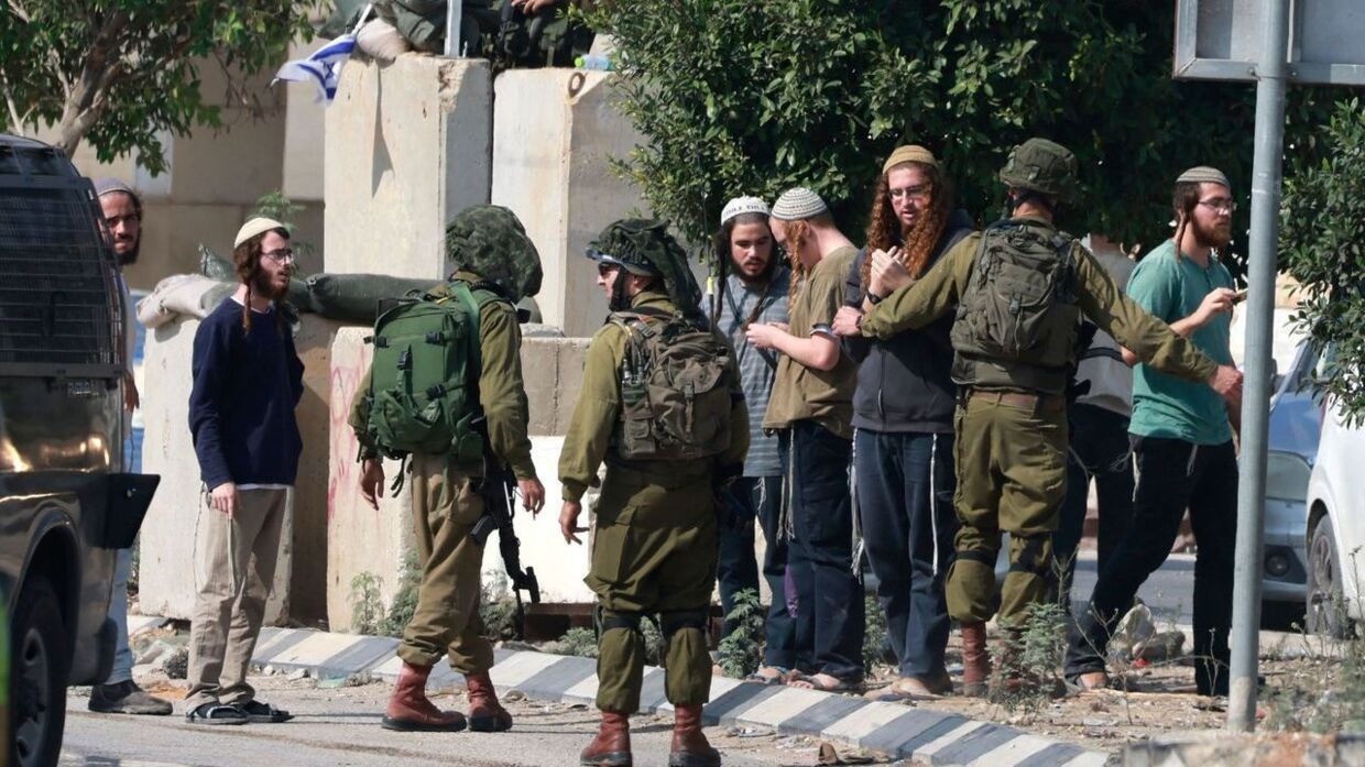 Israelske soldater holder jødiske bosættere tilbage, efter de stormede en palæstinensisk by, som reaktion på drabet på en israelsk mand 2. november. Samme dag blev tre palæstinensere dræbt.