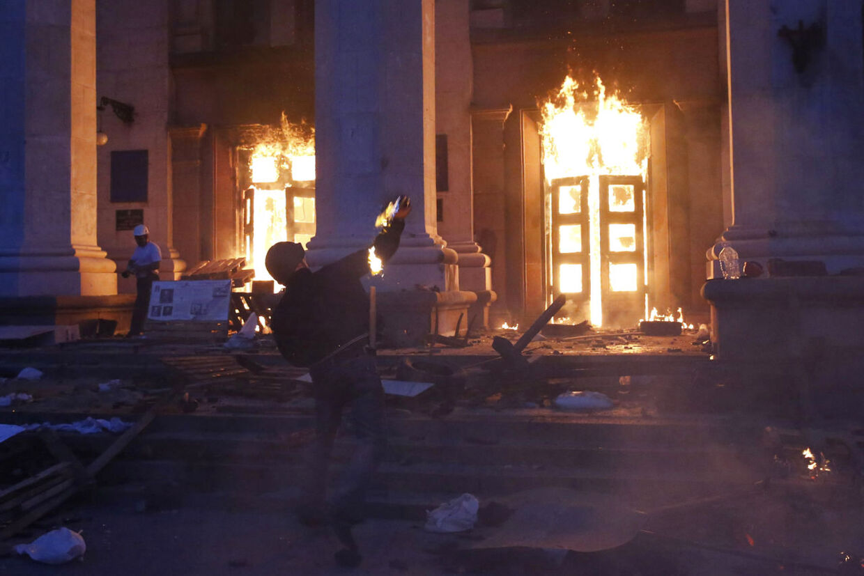 En person smider en molotov-cocktail mod den bygning i det centrale Odessa, hvor mindst 40 personer indebrændte d. 2. maj.
