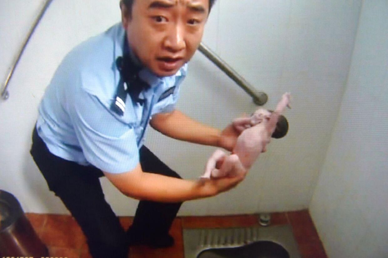 En kinesisk politimand har hevet et nyfødt barn op ad et toilet, efter det var blevet forladt af sin mor.