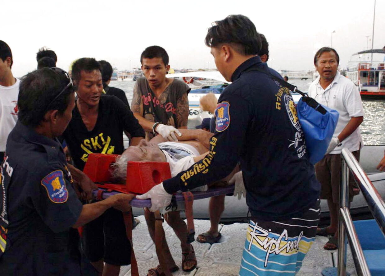 Thailandske redningsfolk bærer en turist, der kom til skade efter en færge sank mellem øen Koh Larn og Pattaya.