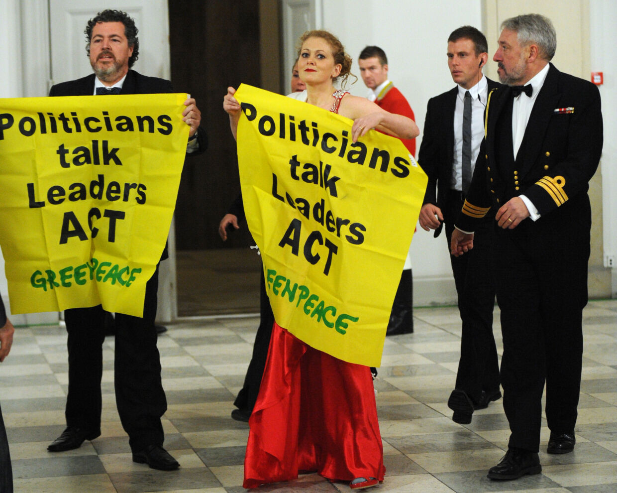 Greenpeace activists unfold a banner distrurbing the arrival of heads of states for the official dinner hosted by Denmark's Queen Margrethe II  in Copenhagen on December 17, 2009 on the 11th day of the COP15 UN Climate Change Conference.     AFP PHOTO POOL/ ERIC FEFERBERG
