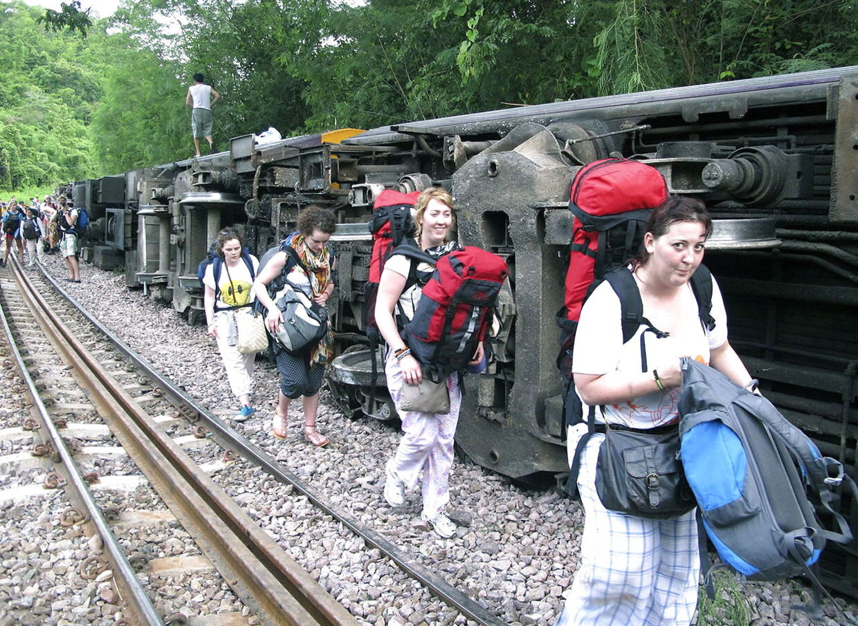 Turister forlader det vægtede tog i Phrae provinsen. 30 passagerer kom til skade, heraf fire alvorligt.