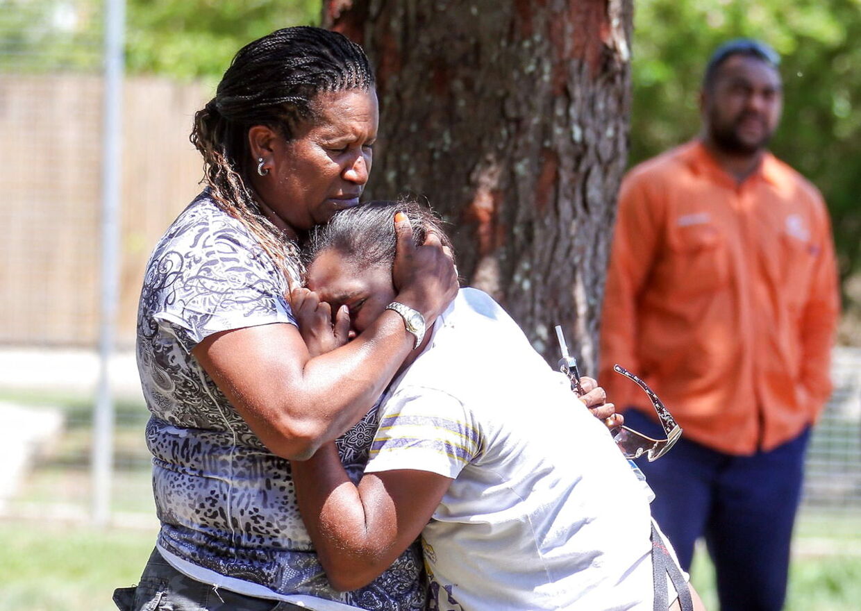 Pårørende og venner sørger nær det hus i Manoora, Cairns, hvor otte børn blev knivdræbt fredag.