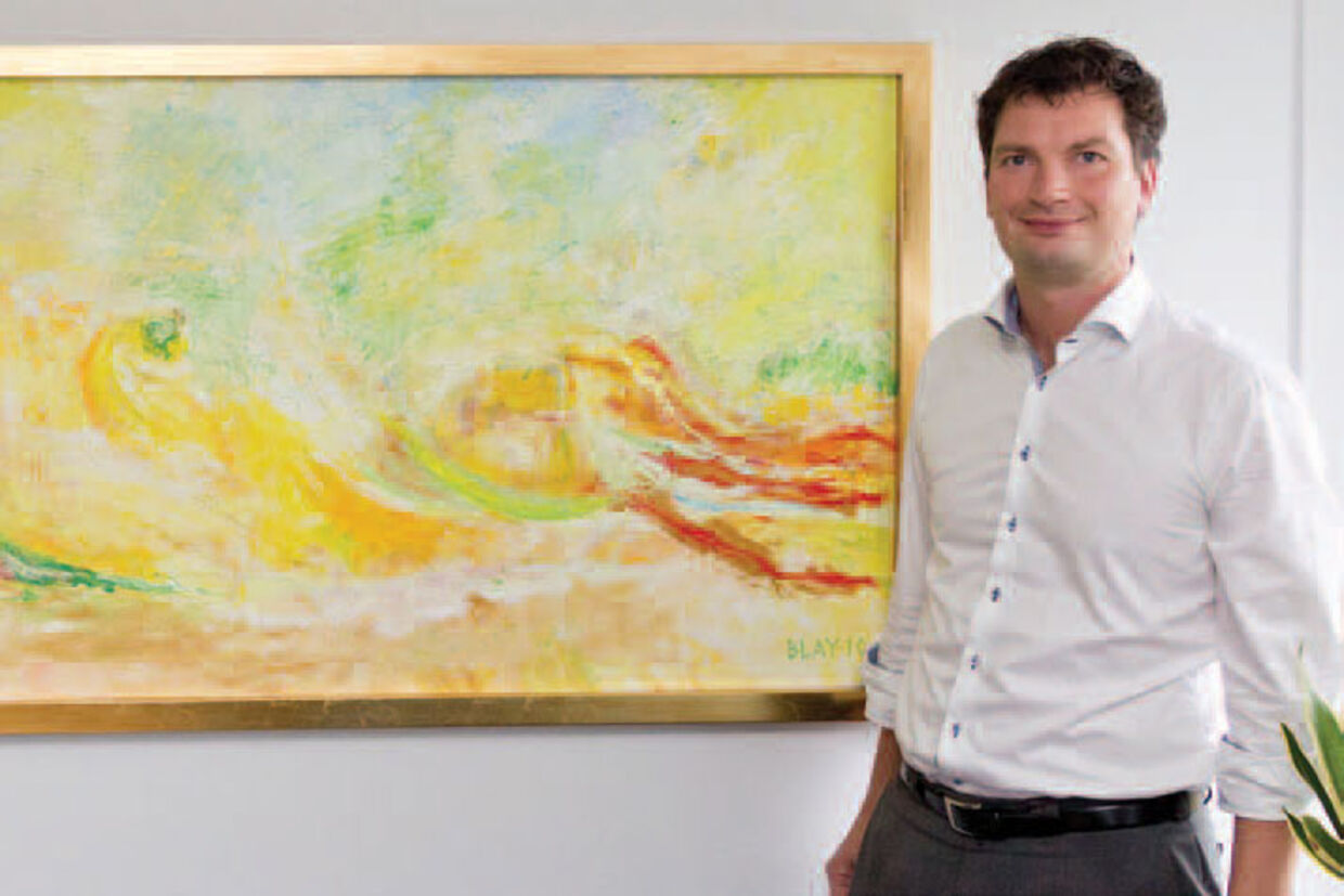 Borgmester Henrik Rasmussen med dét maleri som hans kone har malet, og som hænger på hans kontor.