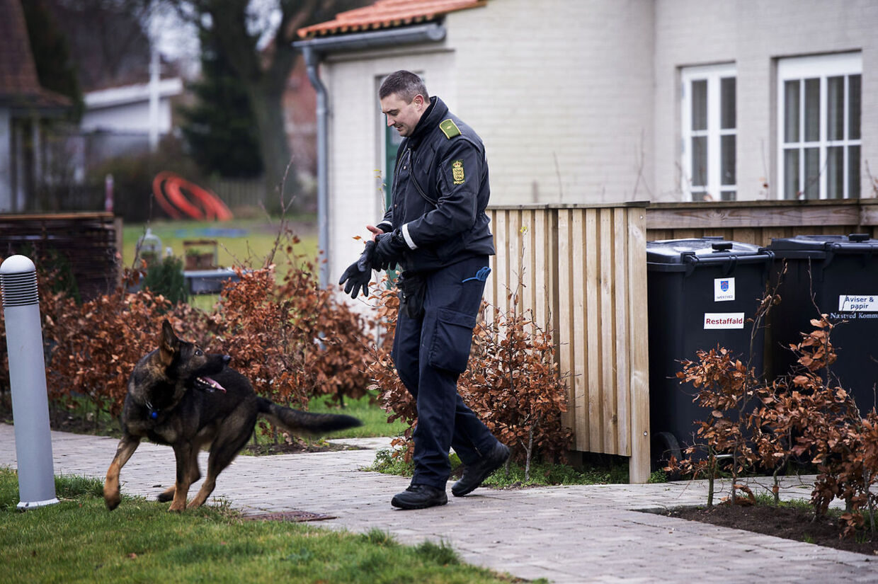 Politiets hundefører undersøger området omkring glasværket ved Holmegård efter knivdrabet.