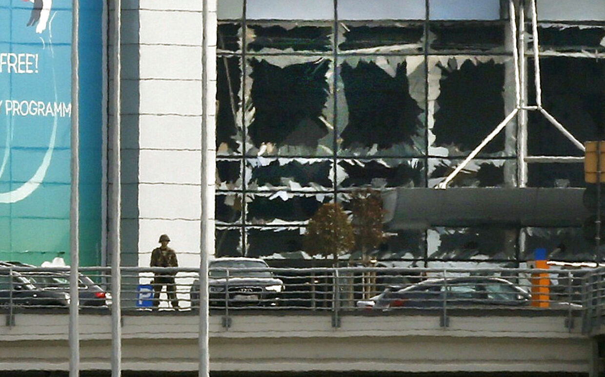 A soldier stands near broken windows after explosions at Zaventem airport near Brussels, Belgium, March 22, 2016. REUTERS/Francois Lenoir