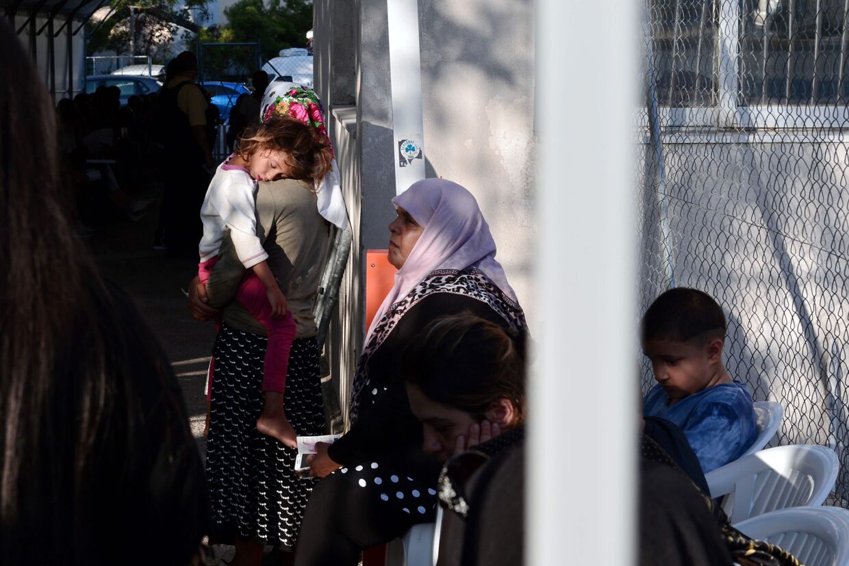 Flygtninge og migranter venter uden for et asylcenter i Athen. Siden aftalen mellem EU og Tyrkiet trådte i kraft i marts, er antallet af nytilkomne flygtninge faldet markant, men omkring 58.000 mennesker er fortsat strandet i Grækenland. Scanpix/Louisa Gouliamaki