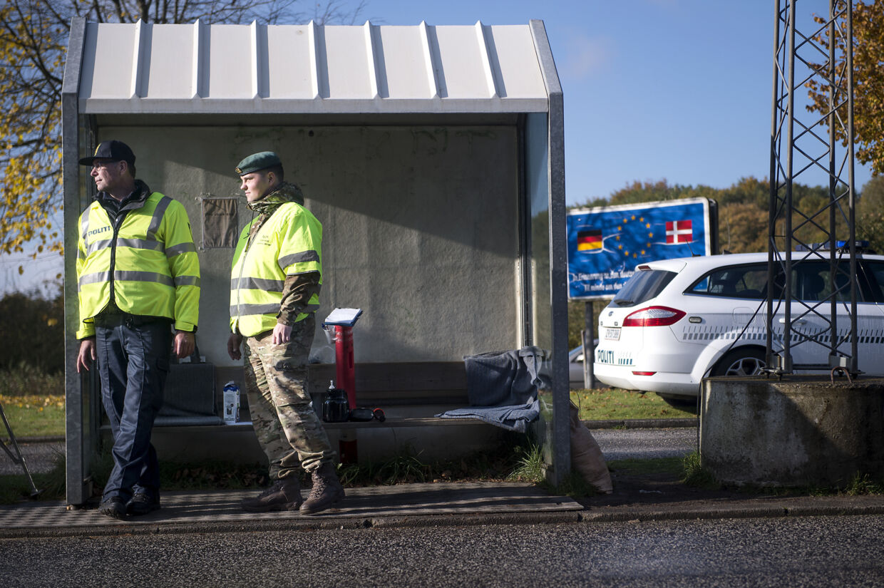 En politibetjent og en hjemmeværnsmand i neonegule veste udgør sammen grænsekontrollen her ved Padborg.